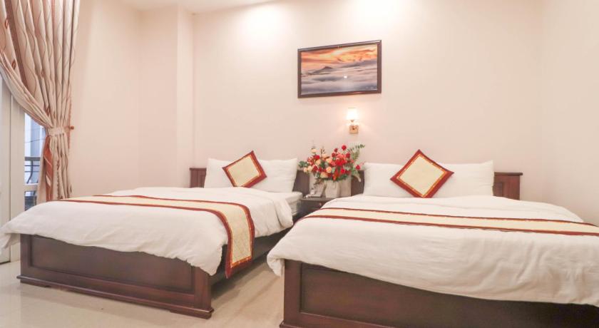 a hotel room with two beds and two nightstands, MAI HOANG HOTEL in Dalat