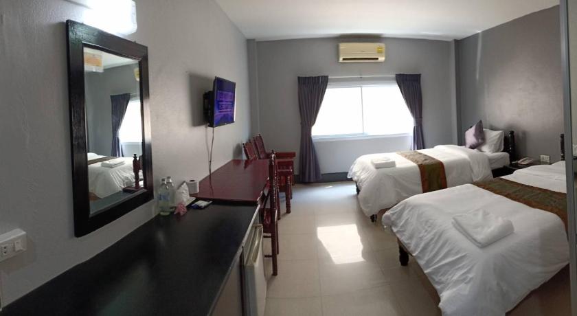 a hotel room with two beds and a television, Submukda phoomplace hotel in Mukdahan