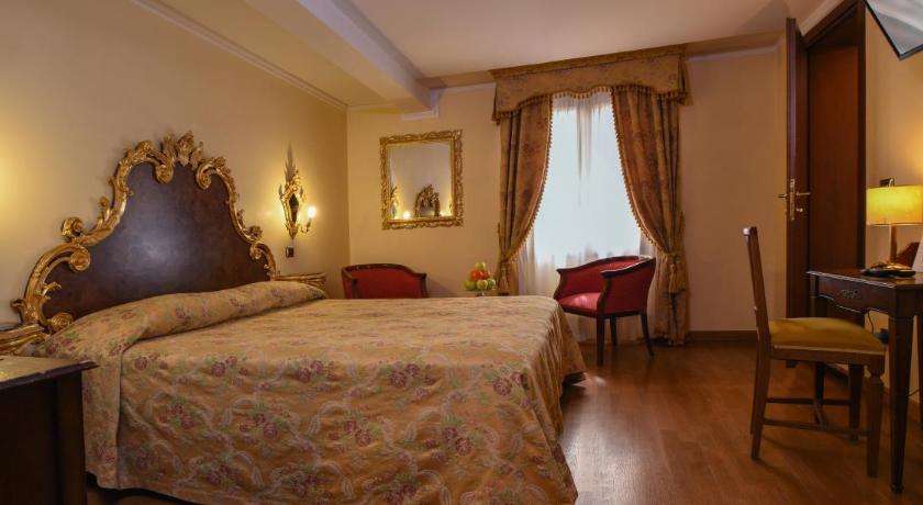a hotel room with a bed, chair, and nightstand, Hotel Ca' Alvise in Venice