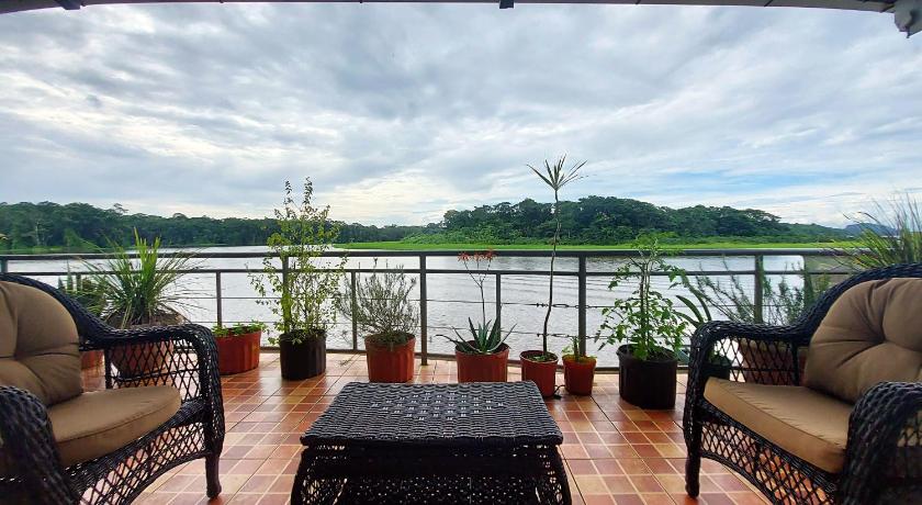 a living room filled with furniture and a balcony, Tortuguero Adventures GuestHouse in Tortuguero