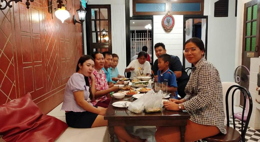 people sitting around a dining room table, At Night in Chumphon