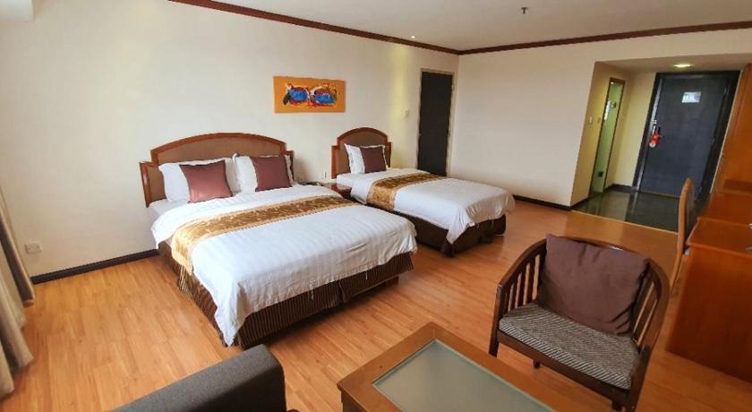 a hotel room with two beds and a desk, Margherita Plaza Hotel in Bintulu