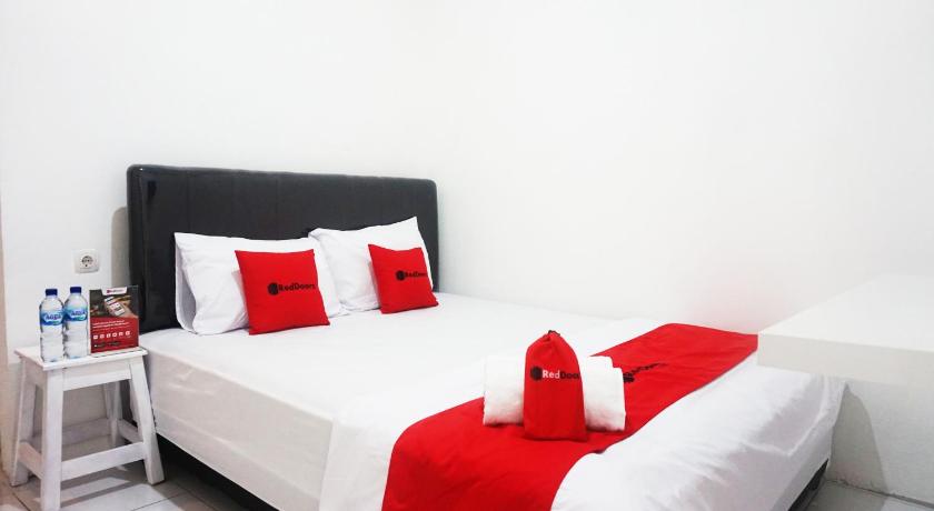 a hotel room with two beds and two lamps, RedDoorz @ Jalan Tanjung Blitar in Blitar
