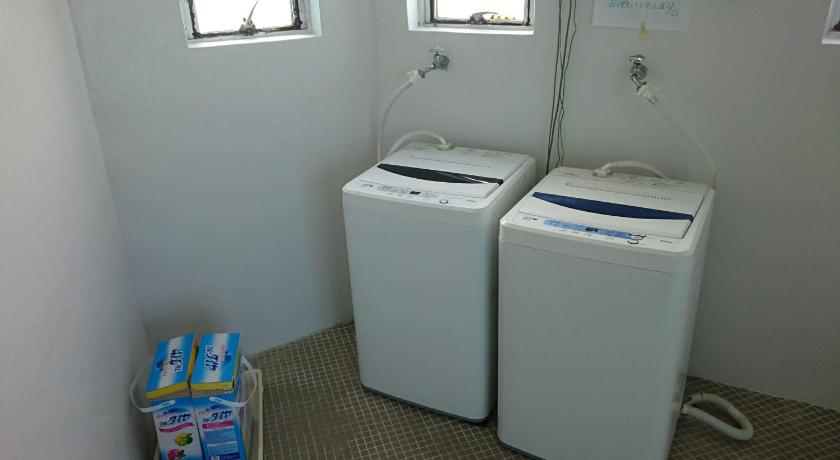 a white toilet sitting next to a white trash can, Eef Condominium Kumejima in Kumejima