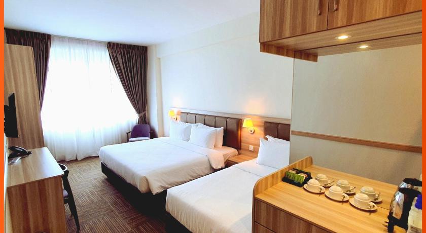 a hotel room with a bed and a dresser, Maple Lodge in Batu Pahat