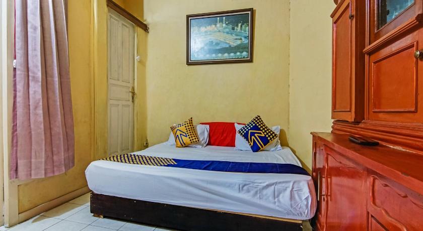 a bed sitting in a bedroom next to a window, SPOT ON 90060 Jq Homestay Syariah in Tangerang