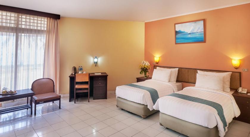 a hotel room with two beds and a desk, PATRA ANYER in Anyer