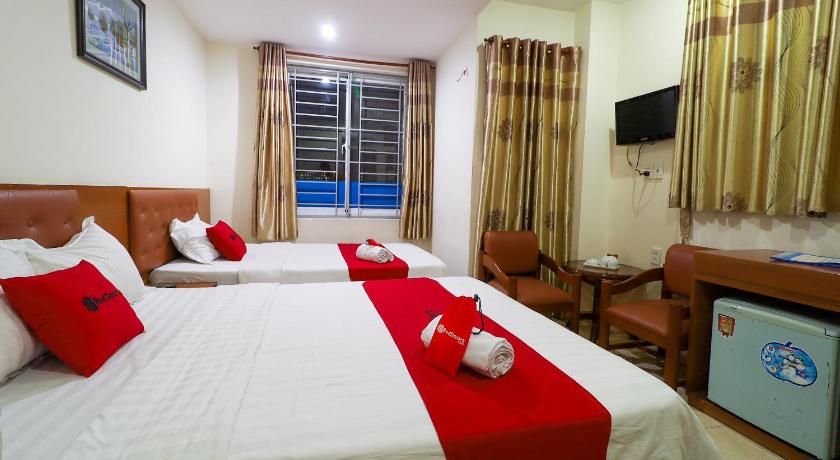 a hotel room with two beds and a television, RedDoorz Hon En Hotel Le Loi Go Vap in Ho Chi Minh City