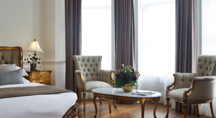 a living room filled with furniture and a window, The Westbridge Hotel Stratford in London
