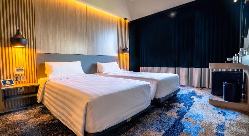 a hotel room with a bed and a night stand, Aston Cilegon Boutique Hotel in Banten