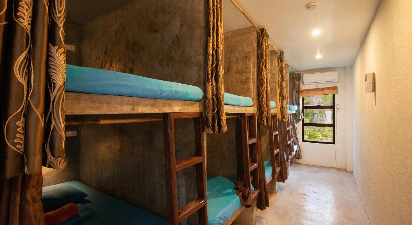a bunk bed in a room with wooden walls, Sunlit Hostel in Siargao Island