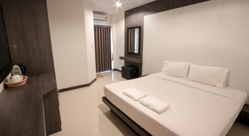 a hotel room with a white bed and white walls, Fortune Mansion in Surin