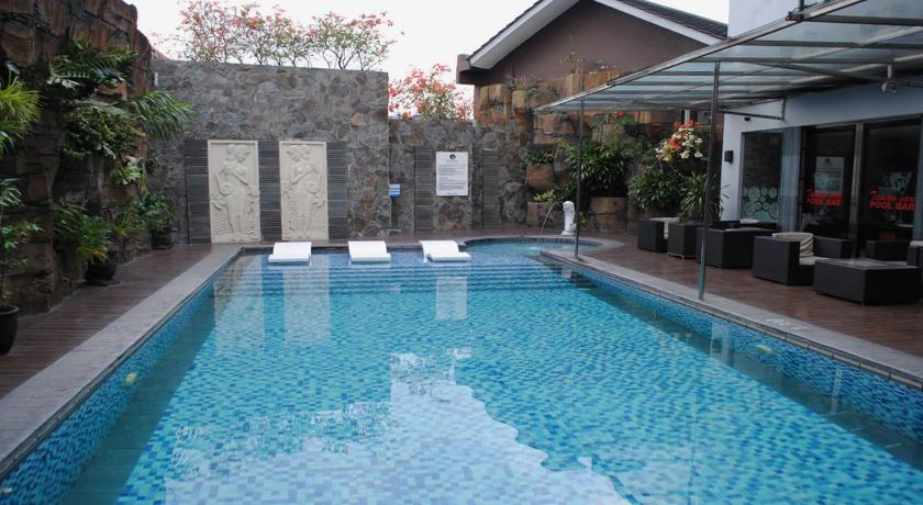 a swimming pool with a pool table and chairs, Hotel Arjuna Yogyakarta in Yogyakarta