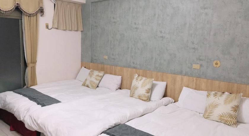 a bed with two pillows and a white comforter, Chia Yun Homestay in Yilan