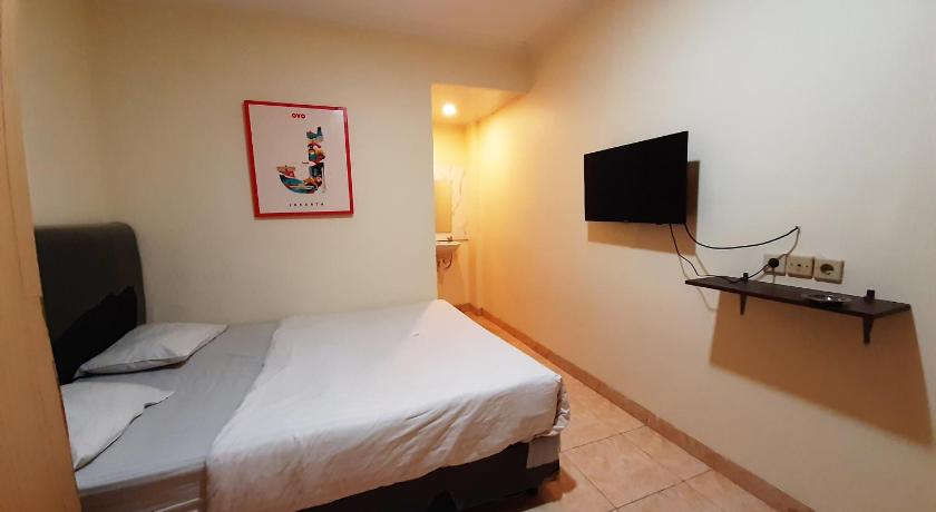 a hotel room with a bed and a television, OYO 868 Wisma Berkat Near Patria Hospital IKKT in Jakarta