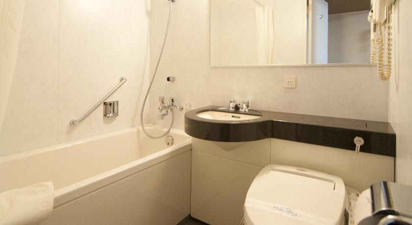 a white toilet sitting next to a bath tub, Hida Hotel Plaza in Takayama