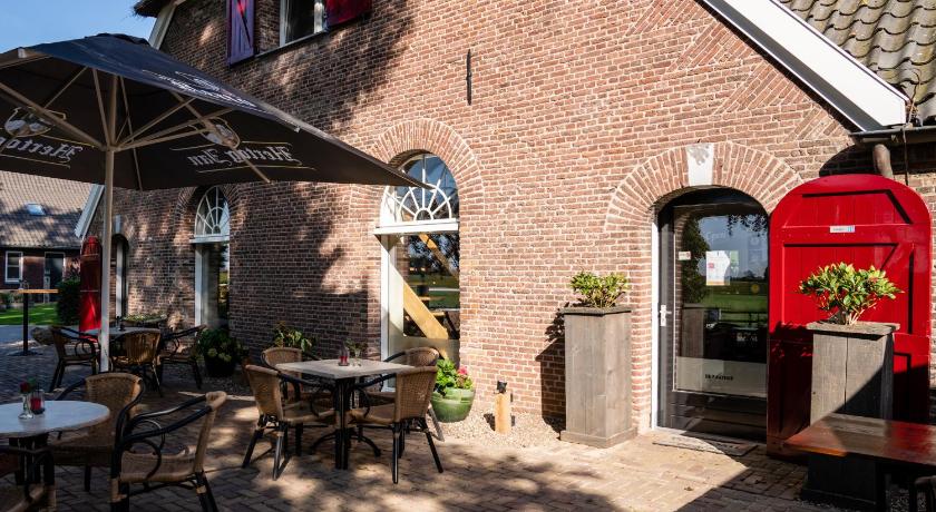 a patio area with a patio table and a patio umbrella, De Raayhof in Pannerden