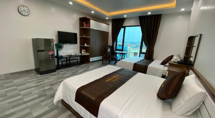 a hotel room with two beds and a tv, Truong Sinh Hotel in Haiphong