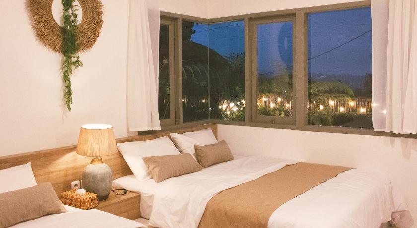a bedroom with a large bed and a large window, Jeje villa in Puncak