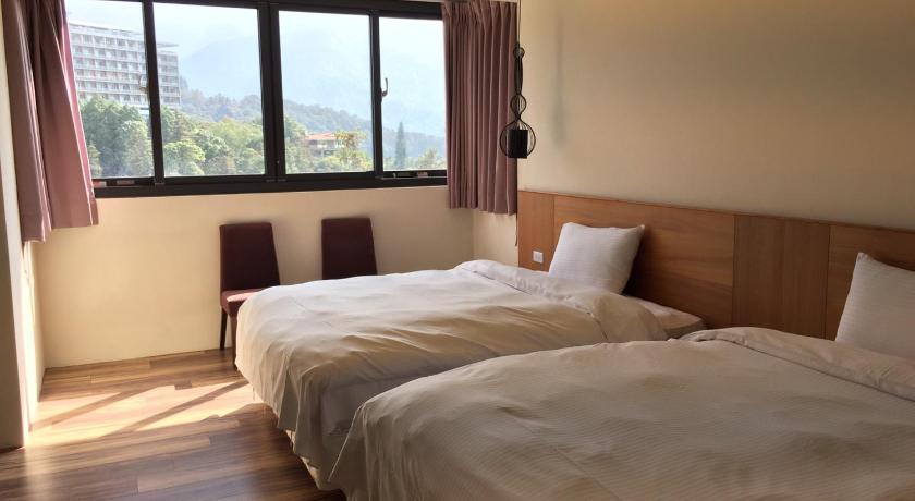 a bedroom with a bed and a window, Miracolo View Hotel in Nantou