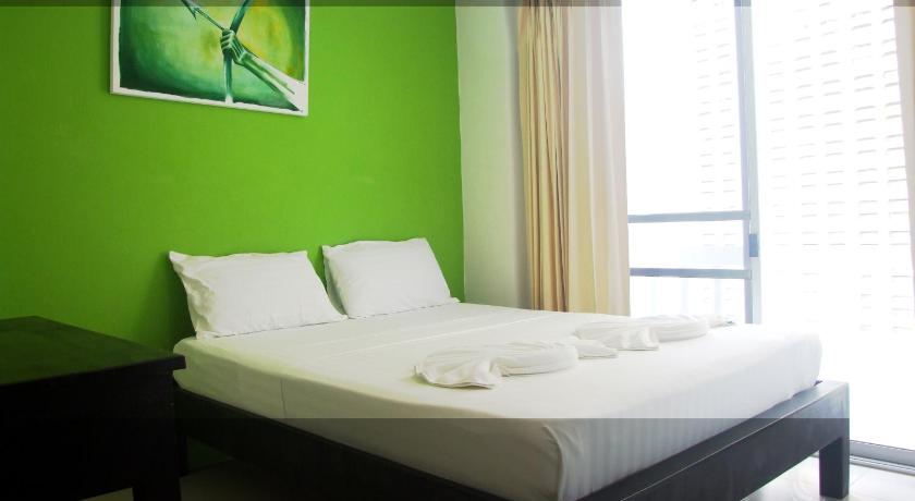 a bedroom with a large bed and a large window, Ivory Phi Phi Island Hotel in Ko Phi Phi