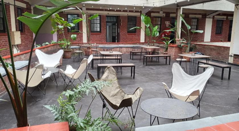 a patio area with tables, chairs and umbrellas, Halo Hybrid Hotel in Durban