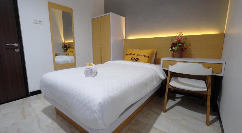 a hotel room with a bed, table and chairs, Gapura Residence in Semarang