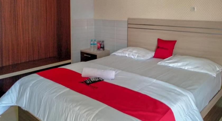 a hotel room with a bed and a dresser, RedDoorz @ Tinggede Area Palu in Palu