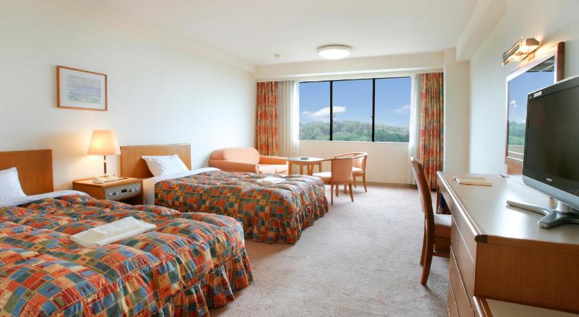 a hotel room with two beds and a television, Royal Hotel TOYAMA TONAMI in Takaoka