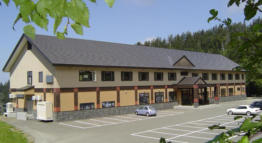 a large white building with a large window on the side of the building, Tokachidake Onsen Ryokan Kamihoroso in Furano