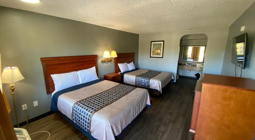 a hotel room with two beds and a television, Americas Best Value Inn Gainesville in Gainesville (FL)