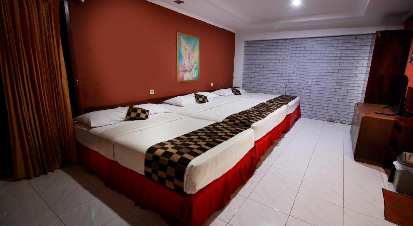 a hotel room with a large bed and a large window, Fora Guesthouse Taman Lingkar in Bandung