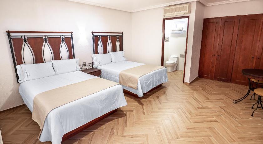 a hotel room with two beds and a dresser, Hotel Alcazar - Guadalajara Centro Historico in Guadalajara