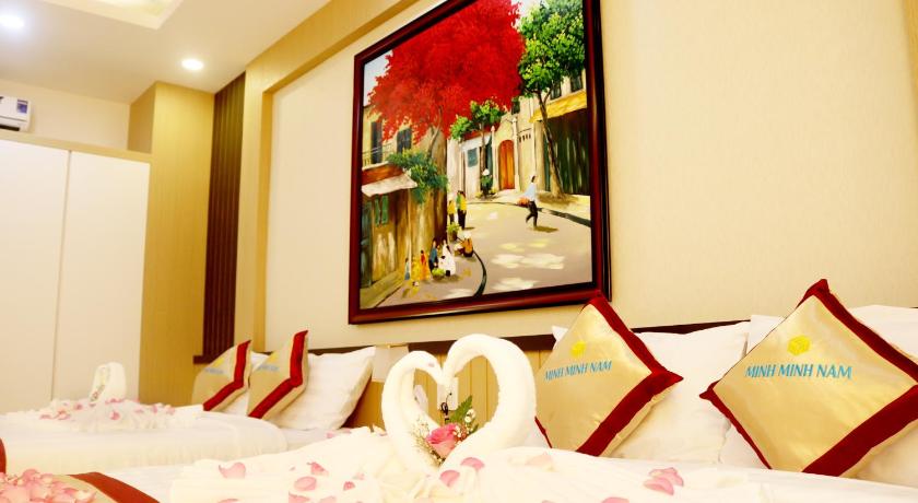 a hotel room with a bed, mirror and a painting on the wall, Minh Minh Nam Hotel in Cần Thơ
