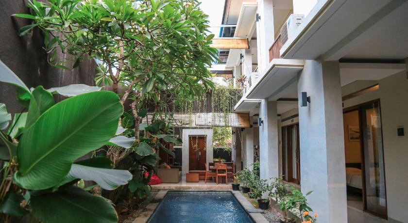 a garden area with a balcony and a building, Alia Home in Bali