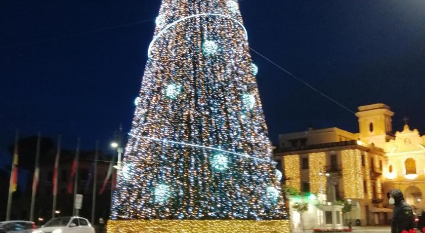 a large christmas tree in front of a clock tower, Palazzo Jannuzzi Relais in Sorrento