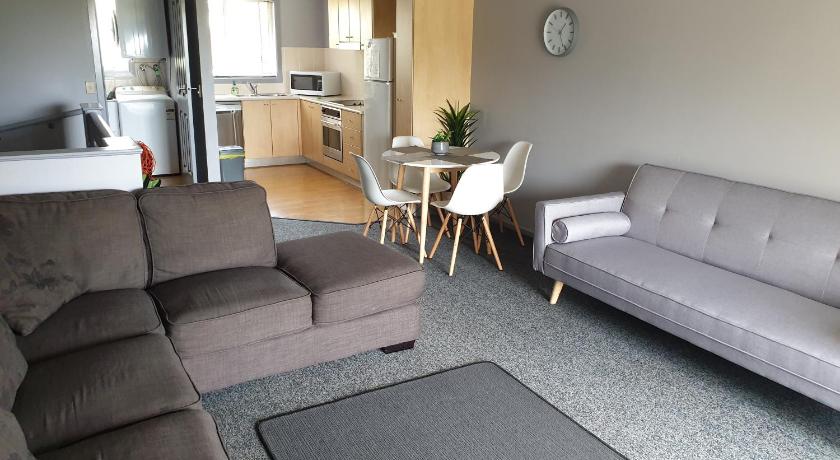 a living room filled with furniture and a couch, Aqualuna Apartments in Coffs Harbour