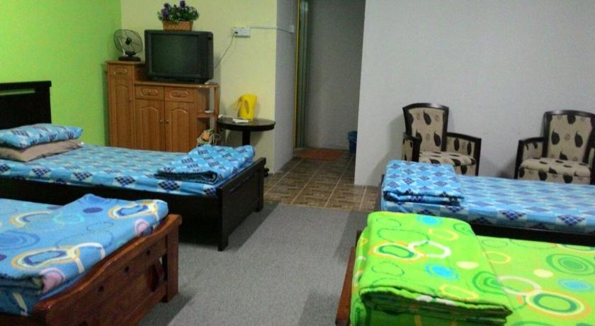 a room with two beds, a desk and a television, Happy Owl in Simpang Pulai