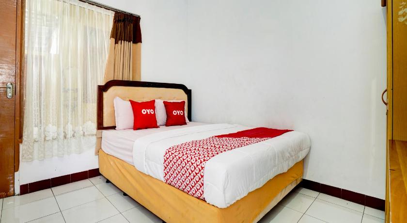 a bedroom with a white bedspread and a white comforter, Super OYO 90118 Hotel Diamond Syariah in Bandung