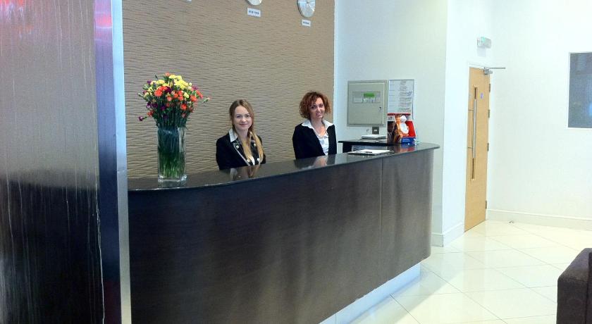 a woman standing next to a man in front of a counter, Cromwell International Hotel in London