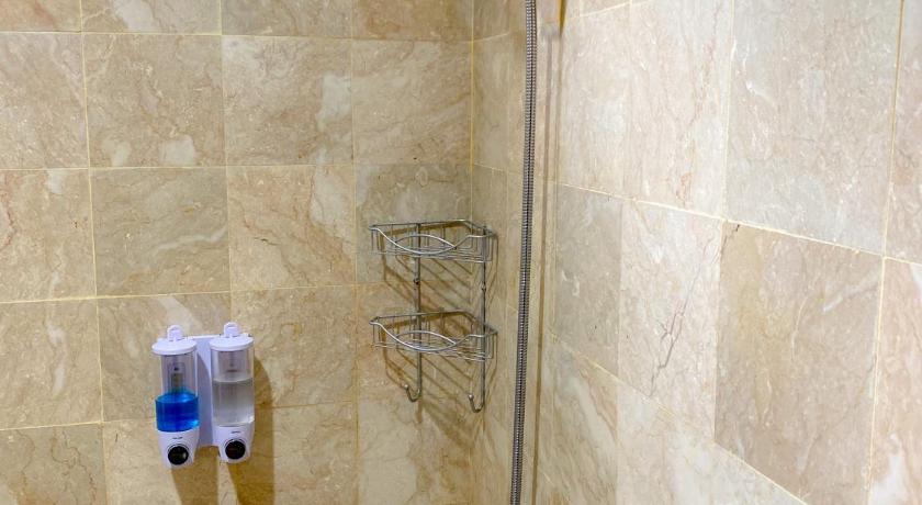 a bathroom with a shower stall and a toilet, AL Marina Resort in Puncak