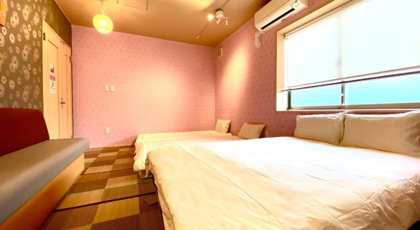 a bedroom with a bed and a window, Hostel Kay 101&102 in Osaka