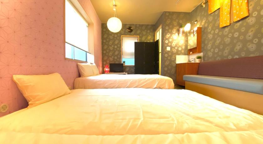 a hotel room with a bed and a television, Hostel Kay 101&102 in Osaka