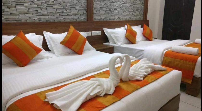 a hotel room with two beds and two lamps, HISHAM SUITES in Kochi