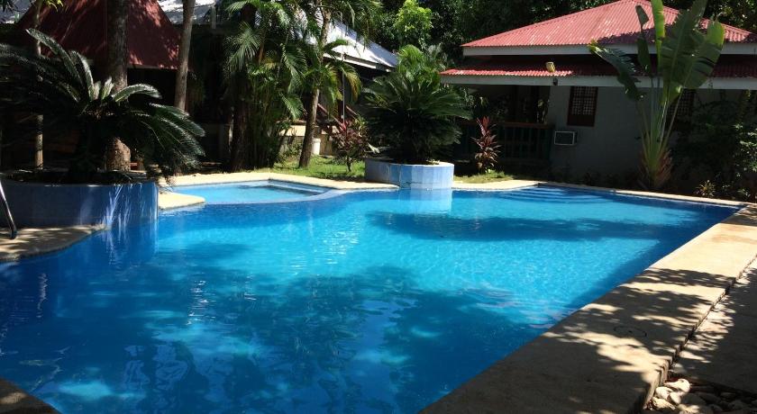 a swimming pool with a pool table and chairs, The Pelicans Resort in Batangas