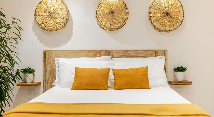 a large white bed with a clock on it, Sorelle Barnaba Country House in Monopoli