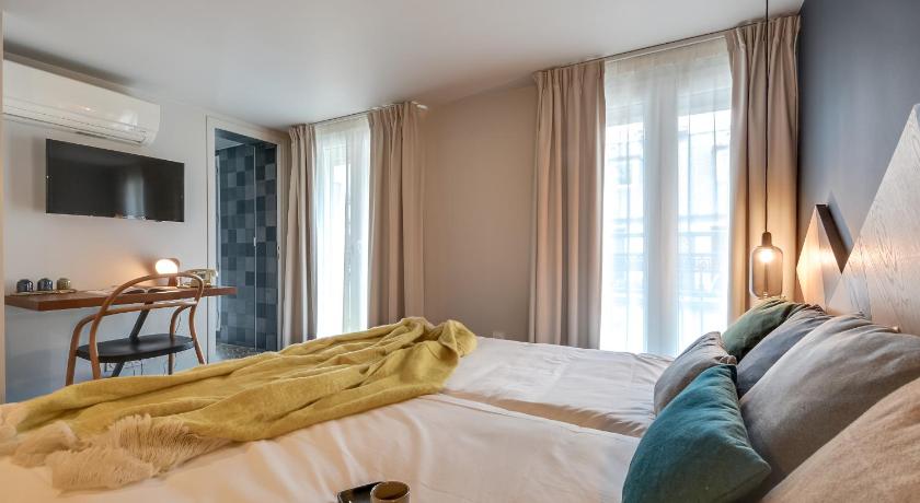 a bed with pillows and pillows in a bedroom, WIT Hotel                                                                        in Paris
