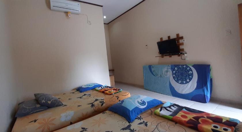 a room with a bed, a desk and a painting on the wall, Andrew batara in Pelabuhan Ratu