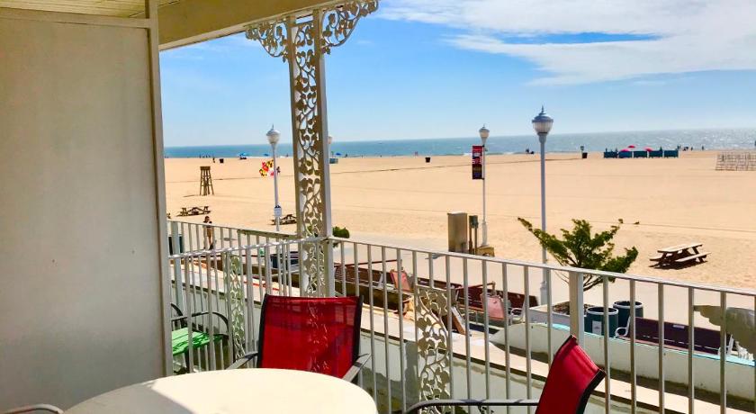 a patio area with chairs, tables and umbrellas, The Colony Apartments in Ocean City (MD)
