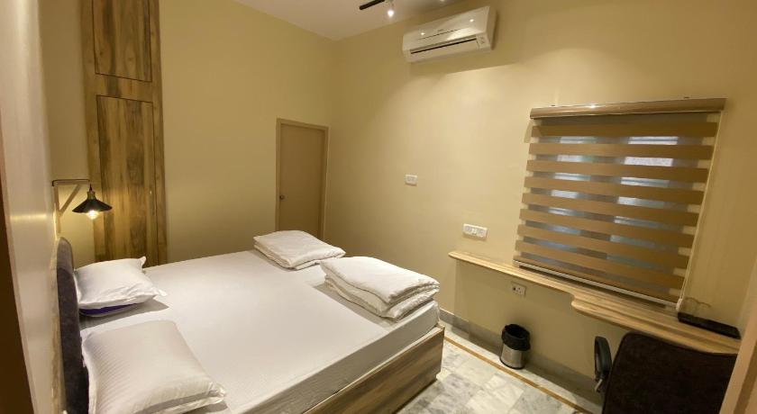 a bedroom with a bed and a desk, Backpackers Den in Lucknow